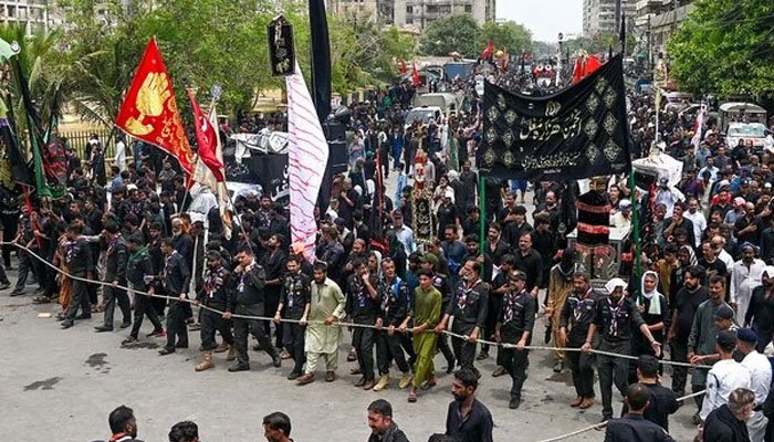 Security personnel standing guard along the route of Karachi's central 8th Muharram procession.