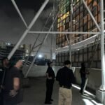 Crane removing a dangerous illegal signboard from Saddar Mobile Market in Karachi during an enforcement operation.