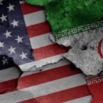 US and Iran flags representing diplomatic tensions and reports of possible negotiations.