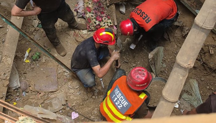 Rescue workers removing debris after a house roof collapsed in Lahore, leaving several people dead and injured.