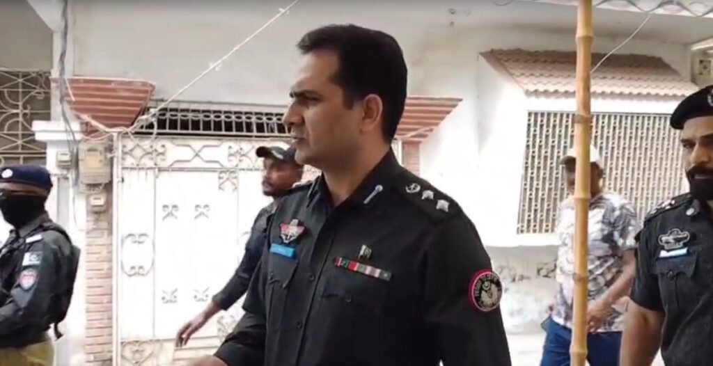 Police officials investigating a firing incident in Azizabad Karachi.