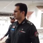 Police officials investigating a firing incident in Azizabad Karachi.