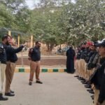 Karachi City District Police officers escort polio vaccination teams during the anti-polio campaign.