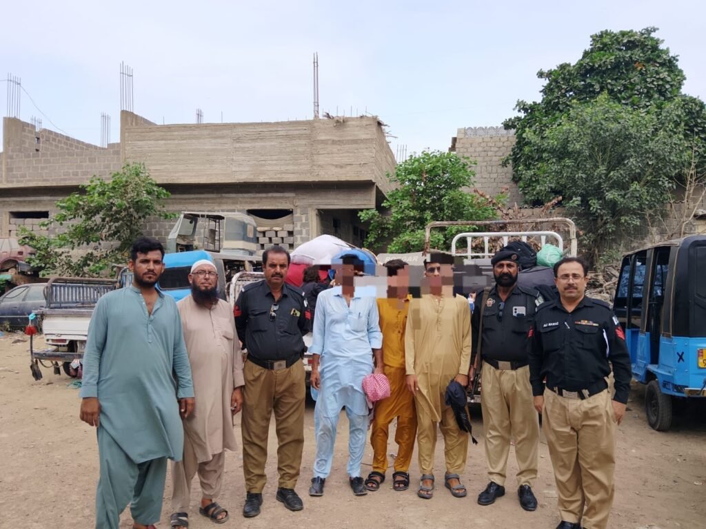 Police escort undocumented Afghan nationals to the GCT Afghan Camp after an operation in Karachi.