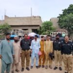 Police escort undocumented Afghan nationals to the GCT Afghan Camp after an operation in Karachi.