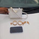 Motorway Police officers hand over a recovered purse containing jewelry and a mobile phone to its rightful owner.
