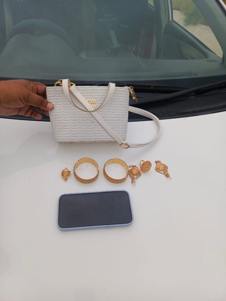 Motorway Police officers hand over a recovered purse containing jewelry and a mobile phone to its rightful owner.