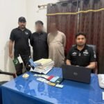 FIA officials detain two suspected illegal passport agents outside the Regional Passport Office in Qambar Shahdadkot.