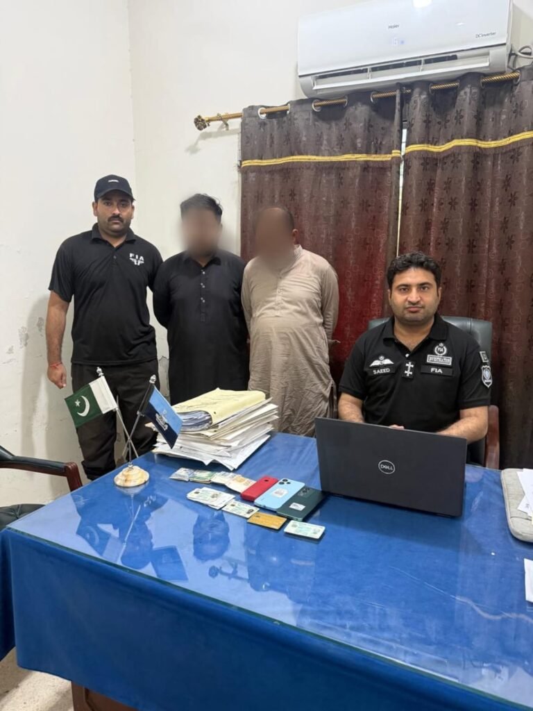 FIA officials detain two suspected illegal passport agents outside the Regional Passport Office in Qambar Shahdadkot.