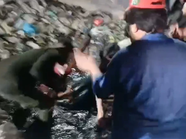 Rescue 1122 personnel conduct a search operation at an open drain in Sohrab Goth, Karachi.