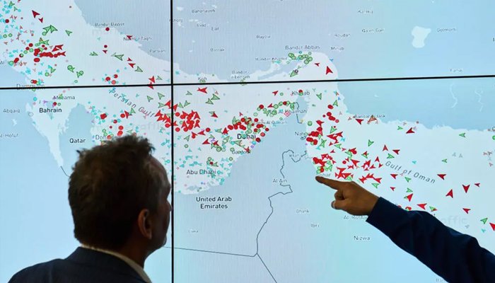Cargo ships sailing through the Strait of Hormuz during US-Iran-Oman diplomatic negotiations.