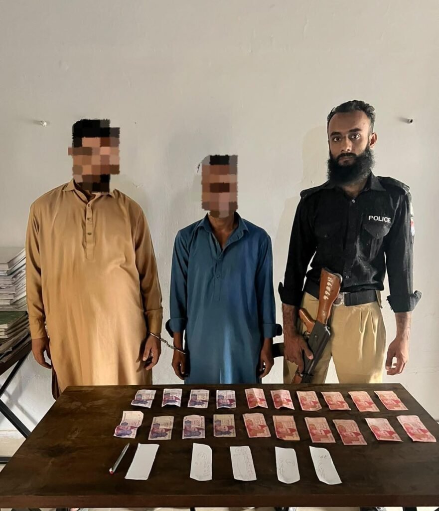 Mominabad Police officers arrest two suspects in a gambling case in Karachi