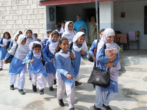 Students entering a government school after the Sindh School Education Department announced new school timings.