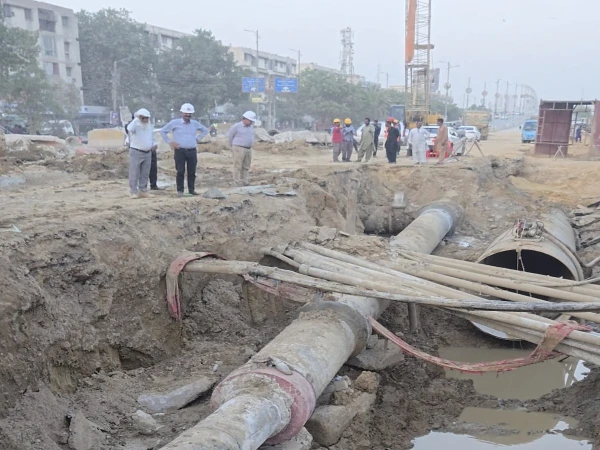 University Road K4 augmentation project construction near Nipa Chowrangi and Hassan Square in Karachi.