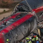 Train Accident in Spain involving two high-speed trains, with derailed carriages and debris near the railway line.