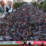 Participants holding Palestinian flags during Gaza solidarity march in Karachi